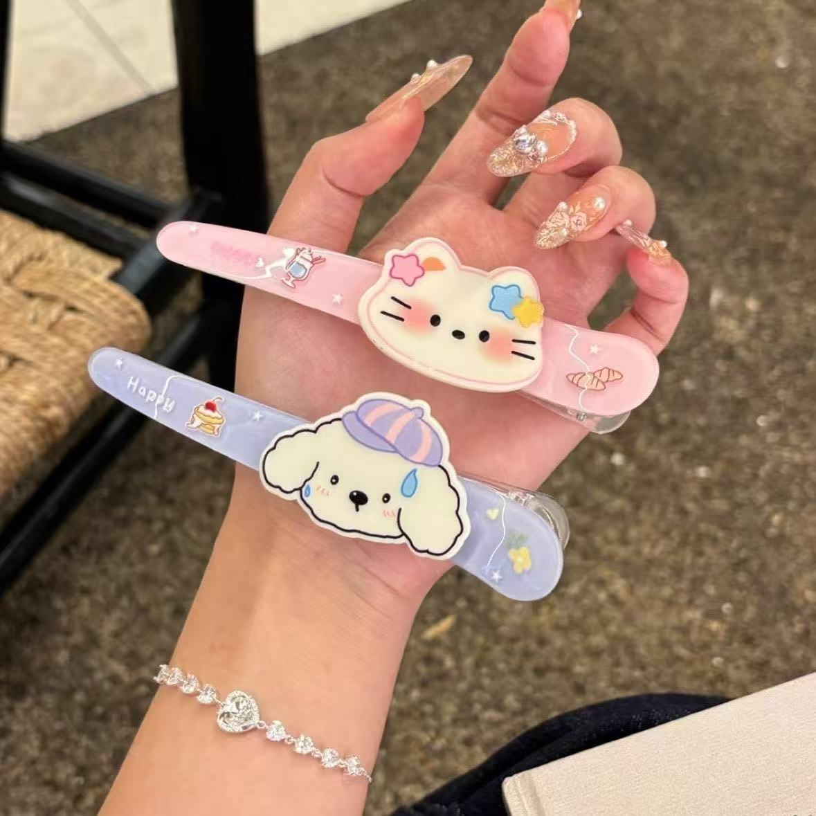 Star kitty and puppy hair clips held together showing detail