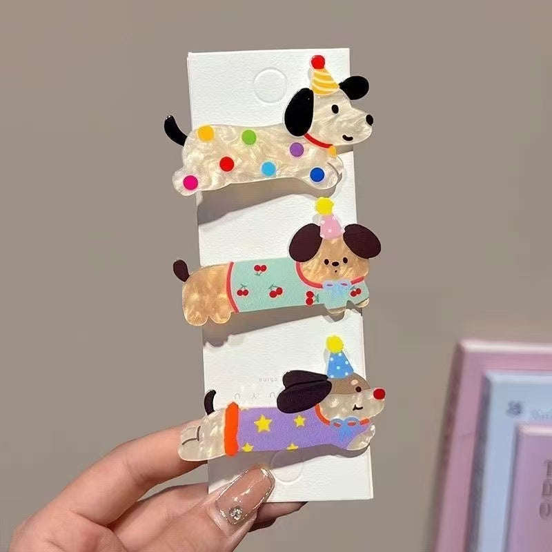 Set of three dog hair clips on display card — polka-dot, cherry, and purple star designs