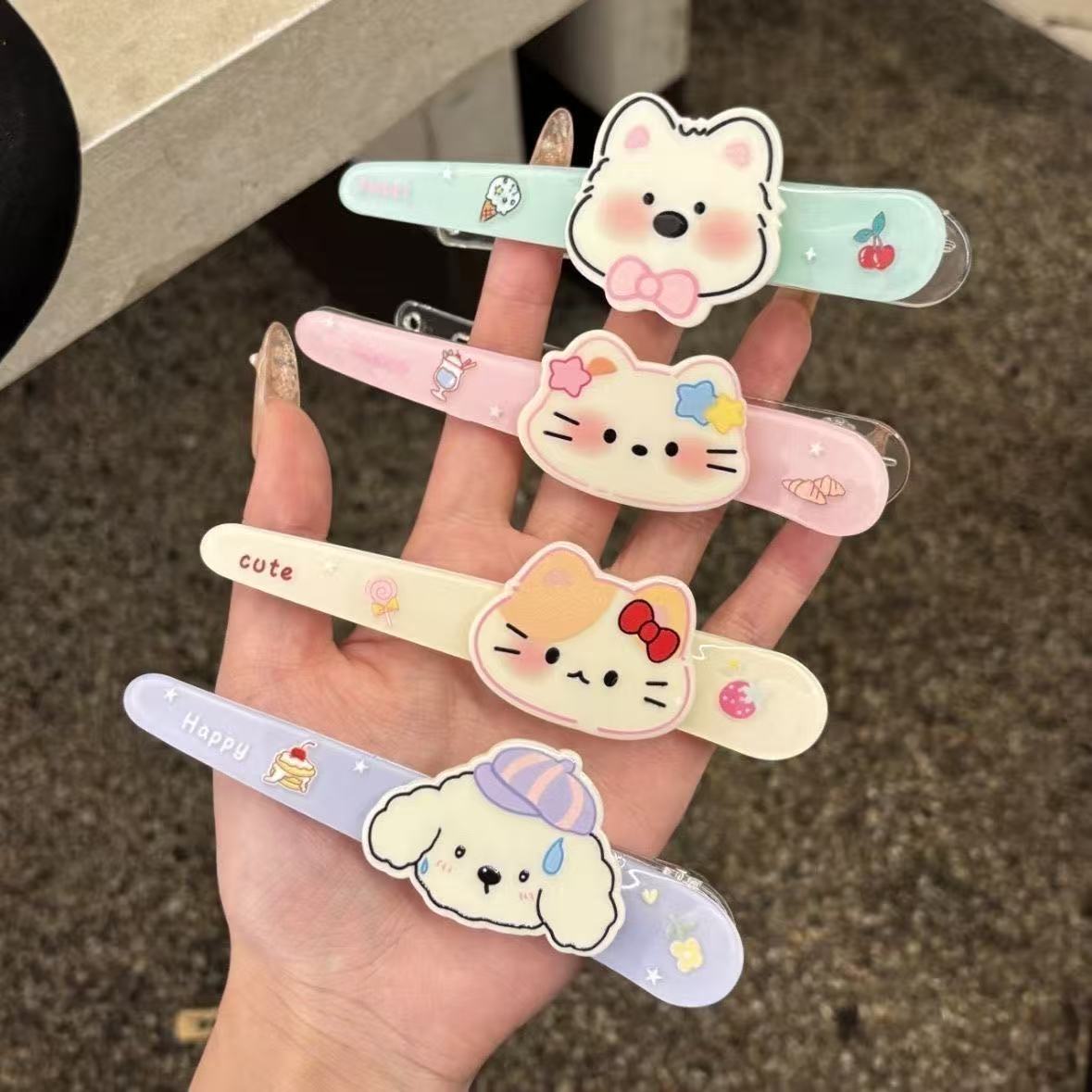 Set of 4 kawaii cartoon hair clips held in hand showing all 4 designs